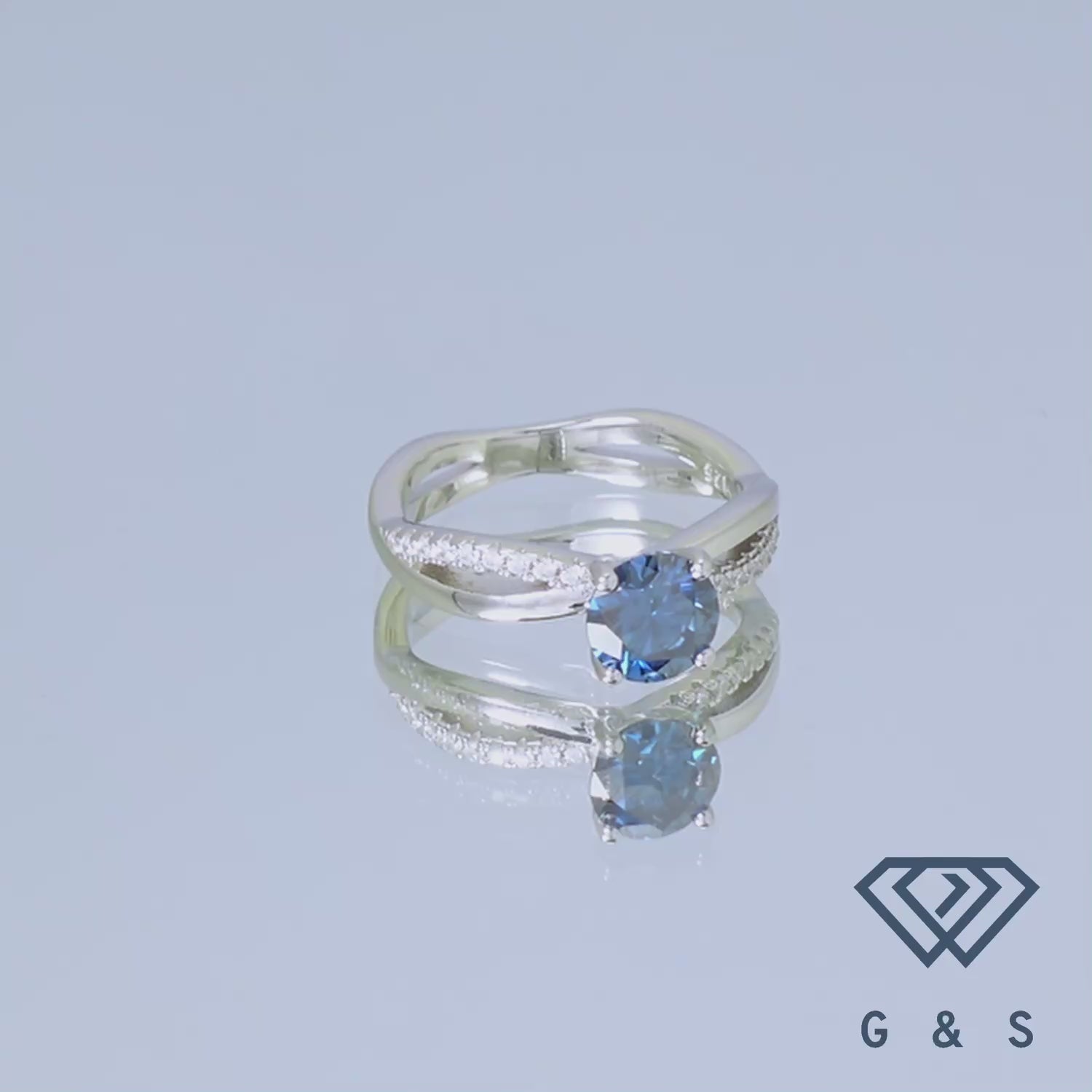 A close-up shot of a sterling silver engagement ring highlighting the sparkling 1.00ct blue moissanite and the elegant infinity symbol, representing eternal love.