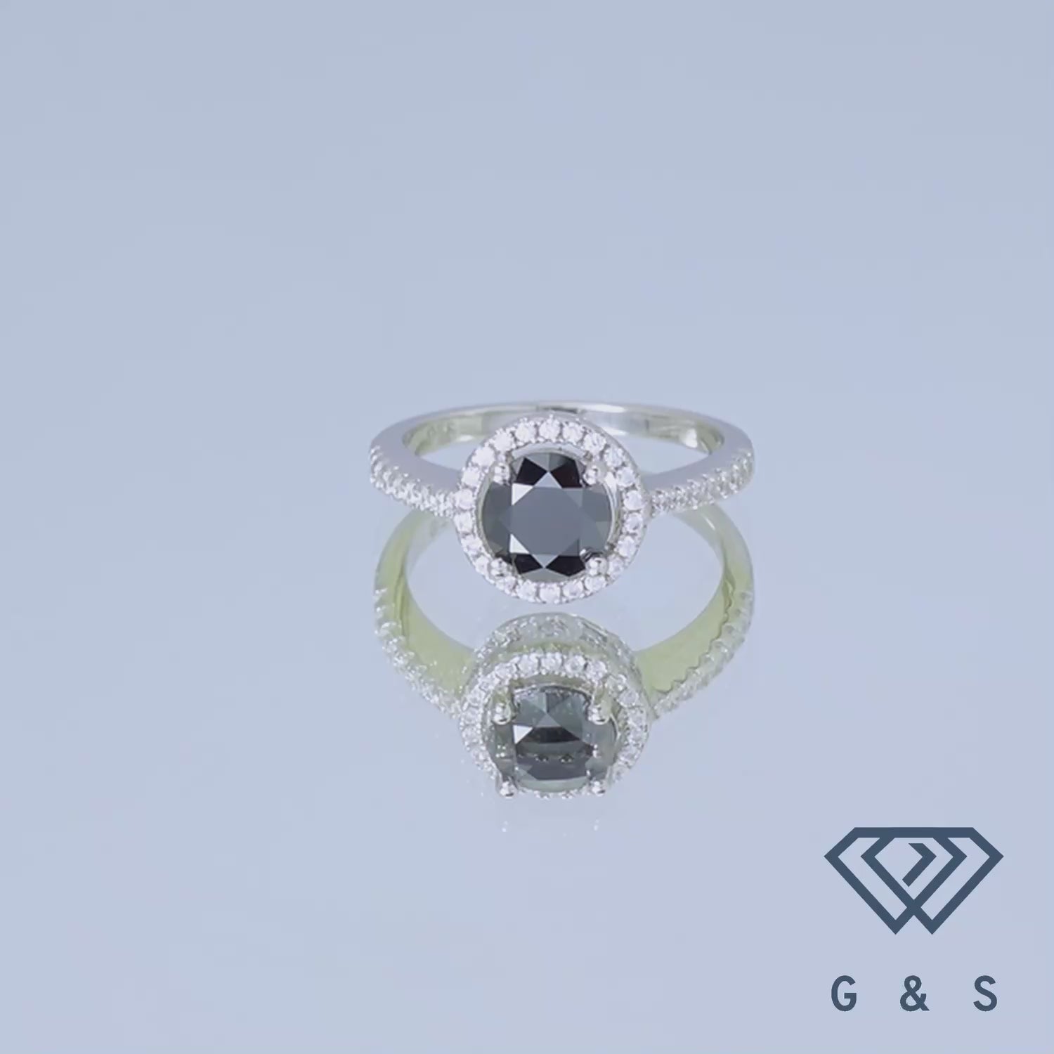 This ring showcases a 1.00ct black moissanite center stone surrounded by a delicate heart-shaped halo, set in a polished sterling silver band.