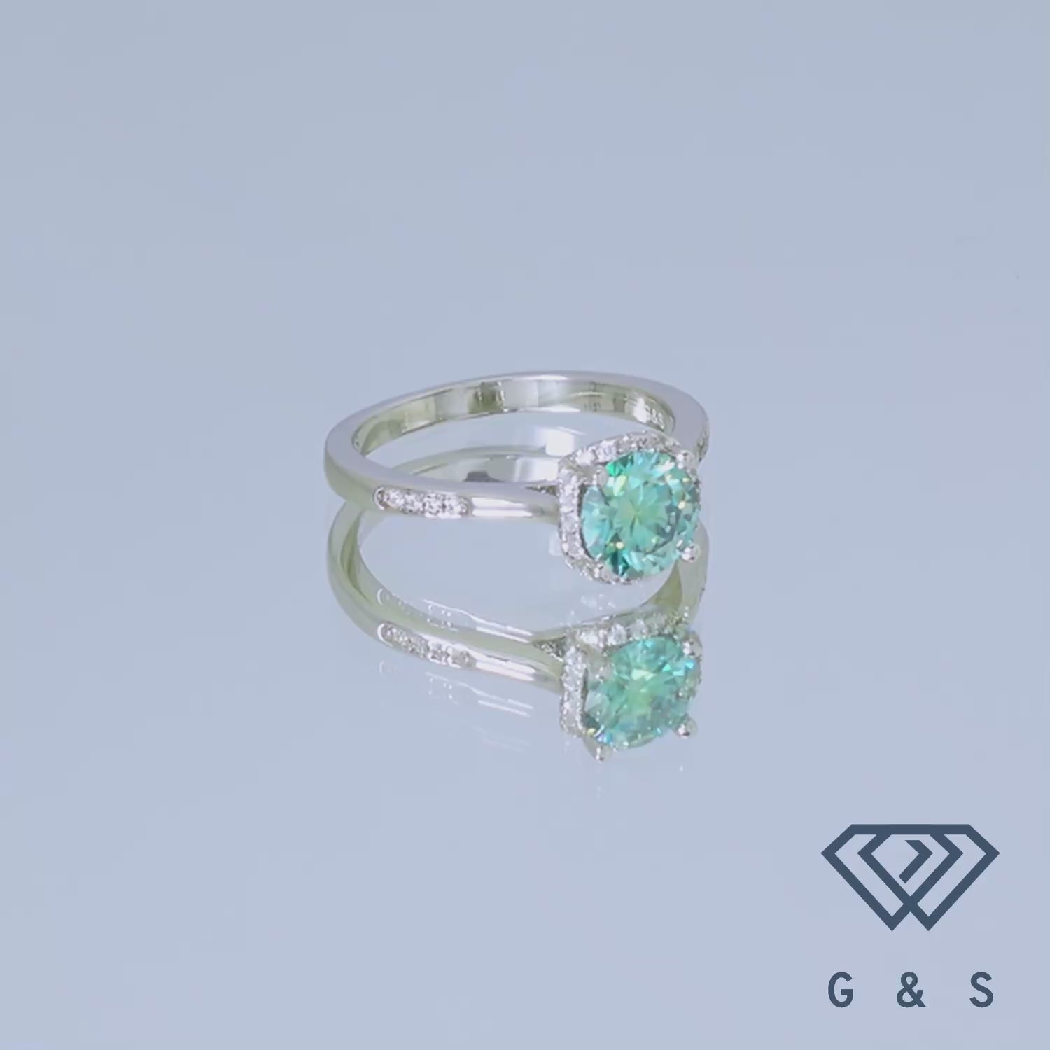 A unique and eye-catching engagement ring showcasing a 1.00ct green moissanite with a modern halo design in polished sterling silver.