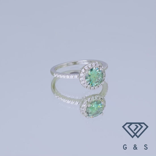Showcasing a rare and exquisite 1.00ct green moissanite, this ring features a classic halo setting that enhances its natural beauty and brilliance.