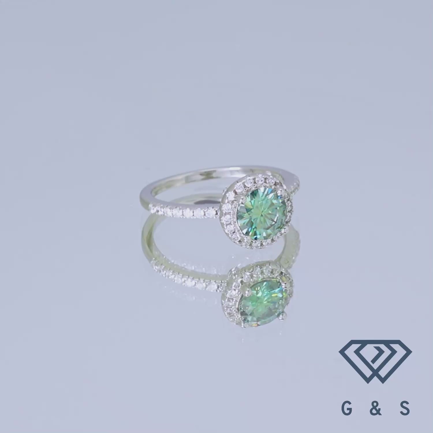 Showcasing a rare and exquisite 1.00ct green moissanite, this ring features a classic halo setting that enhances its natural beauty and brilliance.
