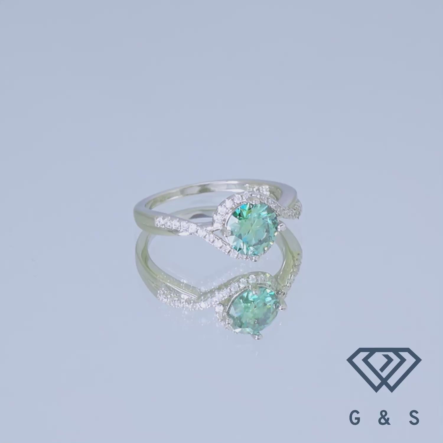 This sterling silver ring features a vibrant green moissanite center stone surrounded by a dazzling halo.