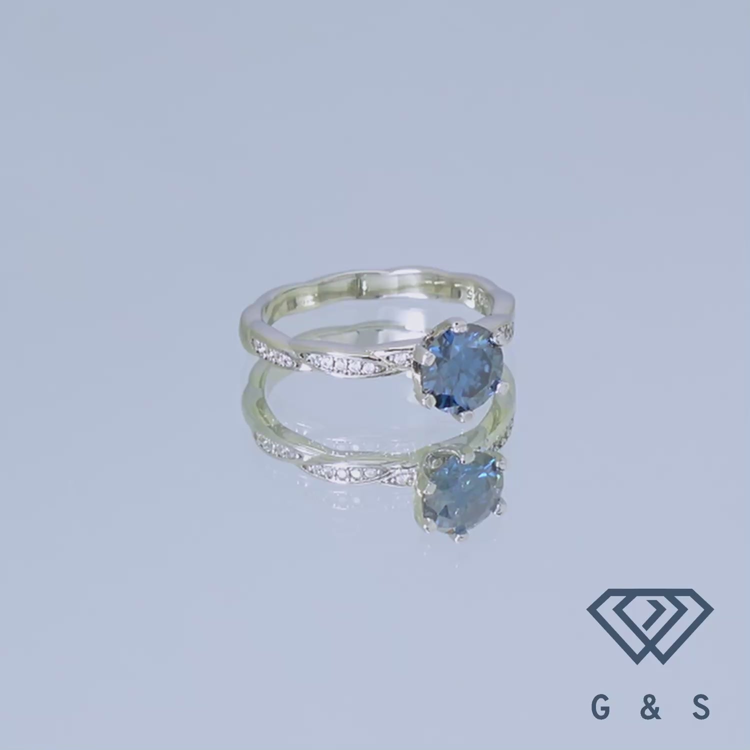 A romantic engagement ring with a 1.00ct blue moissanite, set in a detailed, vintage-style sterling silver band.
