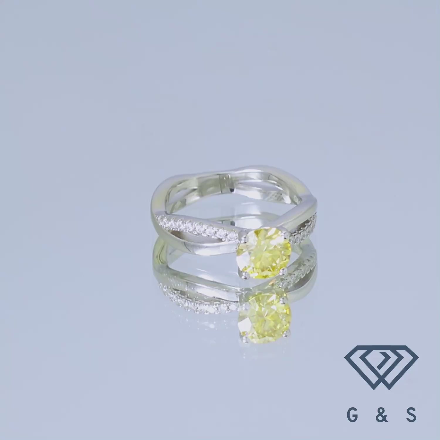This elegant ring showcases a brilliant 1.00ct yellow moissanite, nestled within a flowing infinity motif, symbolizing eternal love, and crafted from high-quality sterling silver.