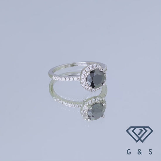 This ring features a bold black moissanite center stone with a classic halo setting, offering a unique and sophisticated alternative to traditional engagement rings.