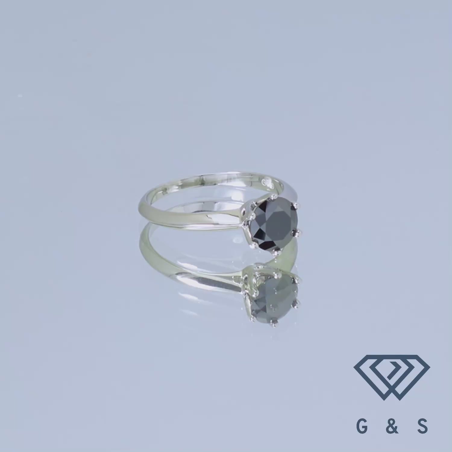A captivating black moissanite solitaire ring featuring the iconic Tiffany six-prong setting, presented in a sleek sterling silver band.