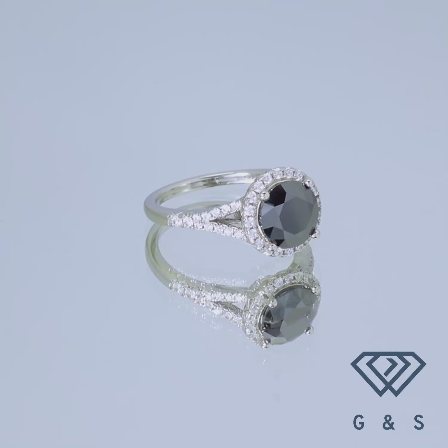 This stunning ring showcases a 2.00ct moissanite center stone accented by a dramatic black halo, offering a bold and contemporary style.