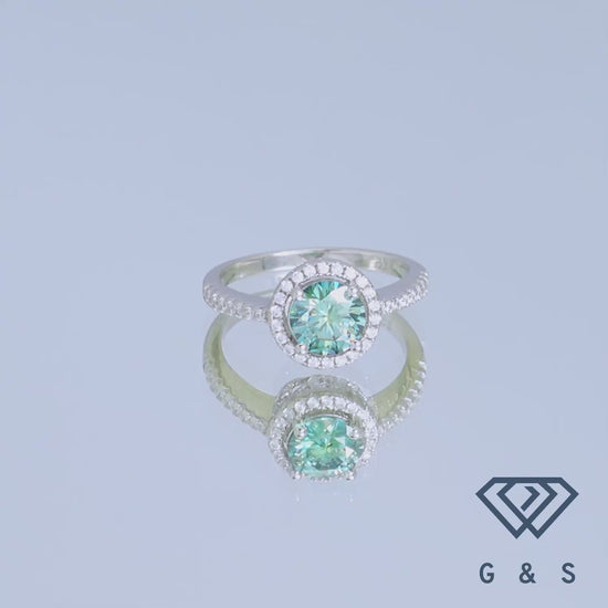 A romantic sterling silver engagement ring highlighting a vibrant 1.00ct green moissanite with a delicate heart-shaped halo setting.