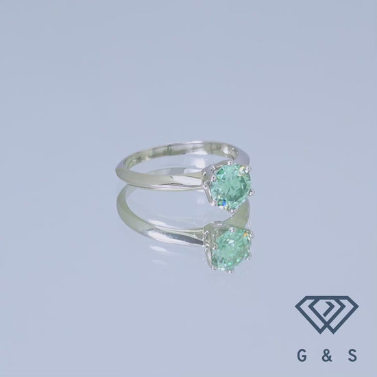 A simple yet elegant sterling silver ring showcasing a 1.00ct green moissanite held in a secure six-prong setting, reminiscent of the iconic Tiffany design.