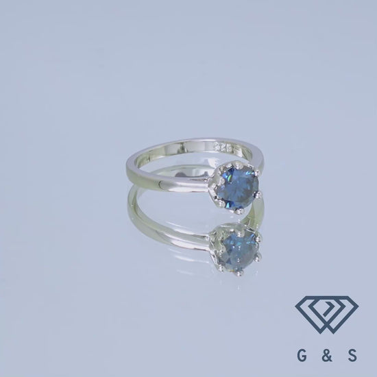 A delicate sterling silver engagement ring featuring a 1.00ct blue moissanite, set in a six-claw floral basket setting.