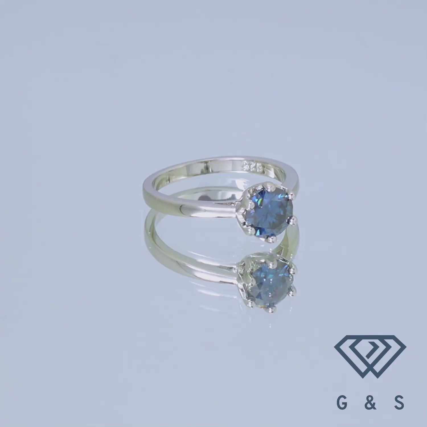 A delicate sterling silver engagement ring featuring a 1.00ct blue moissanite, set in a six-claw floral basket setting.