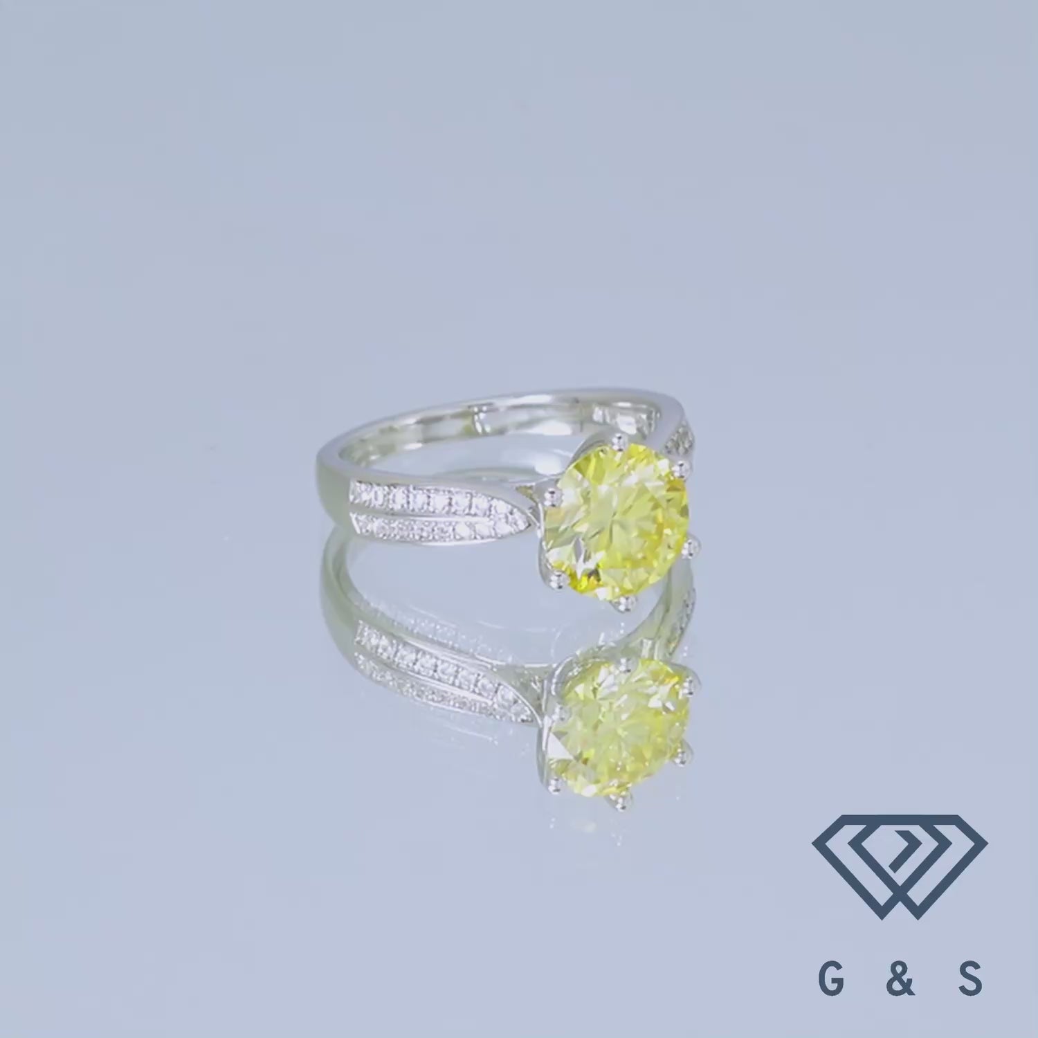 This sterling silver ring showcases a dazzling 2.00ct yellow moissanite, accented by a classic pave band for added brilliance.