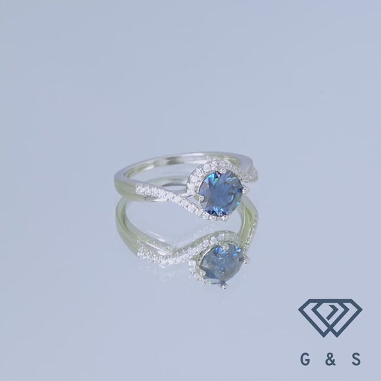 A stunning engagement ring with a 1.00ct blue moissanite and a dazzling halo, set in elegant sterling silver.
