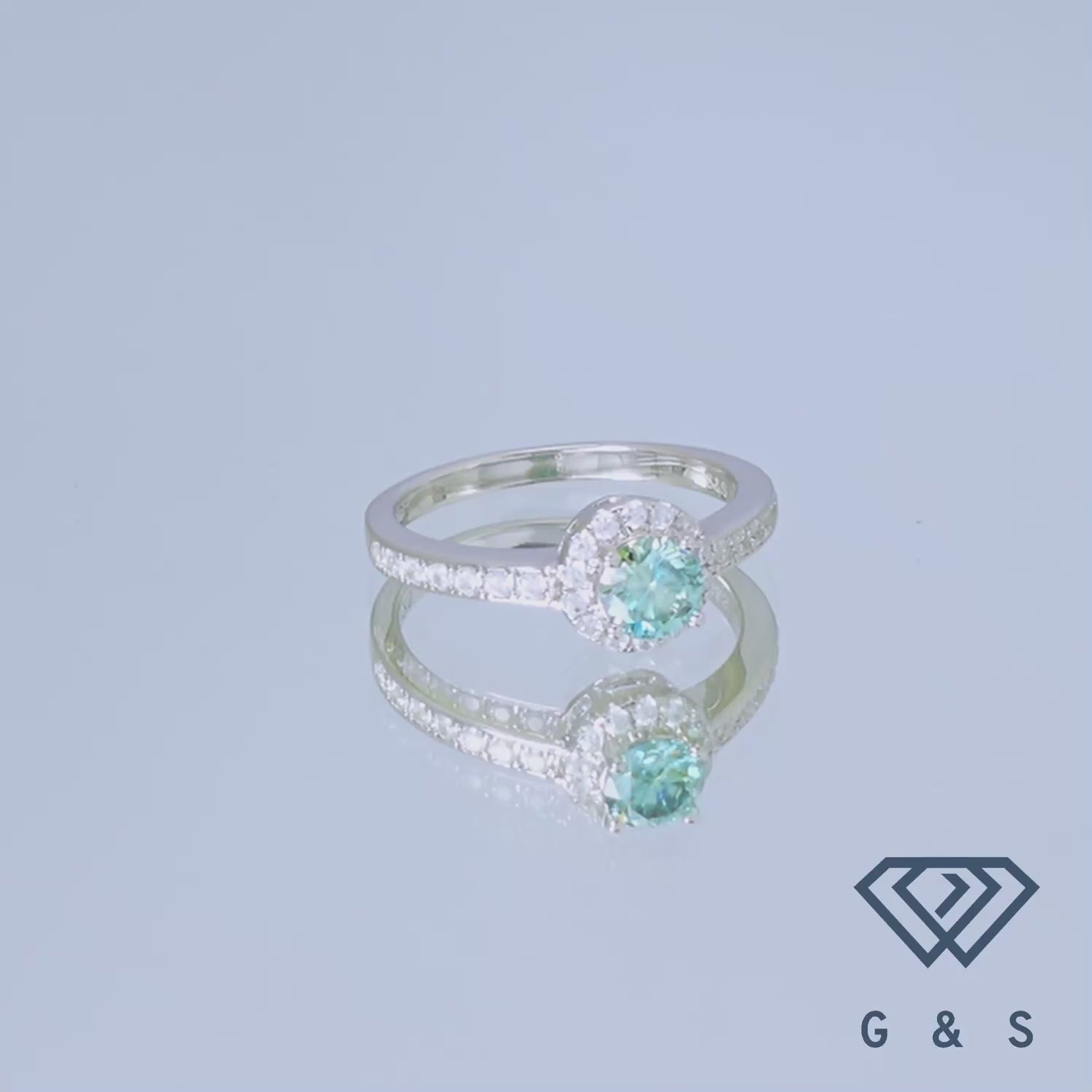 This elegant ring showcases a 0.50ct green moissanite with a delicate pave halo setting on a polished sterling silver band.