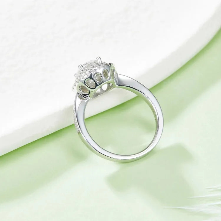 A beautiful ring featuring a round brilliant moissanite center stone and a double halo of smaller stones.