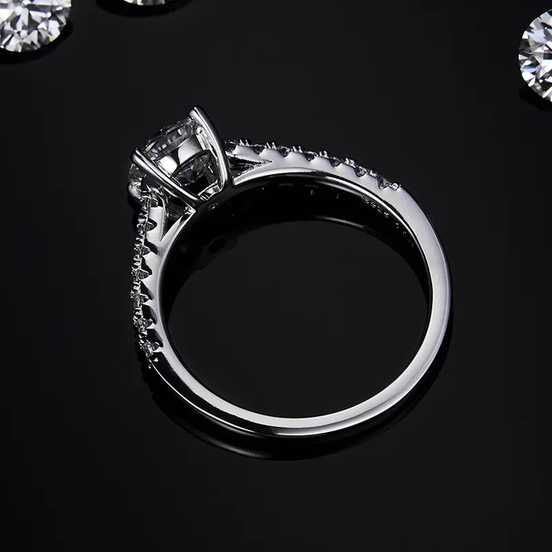 This engagement ring features a stunning 1.00ct round brilliant moissanite, set on a slender and refined sterling silver band, perfect for a timeless and sophisticated look.