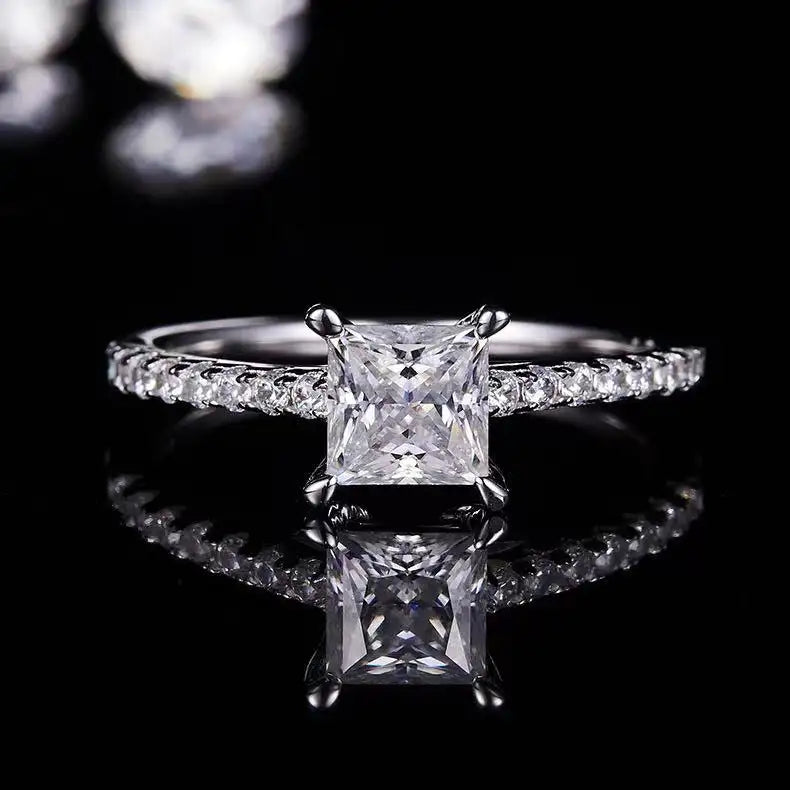 This engagement ring features a 1.00ct princess cut moissanite held securely in a basket setting, offering both elegance and durability.